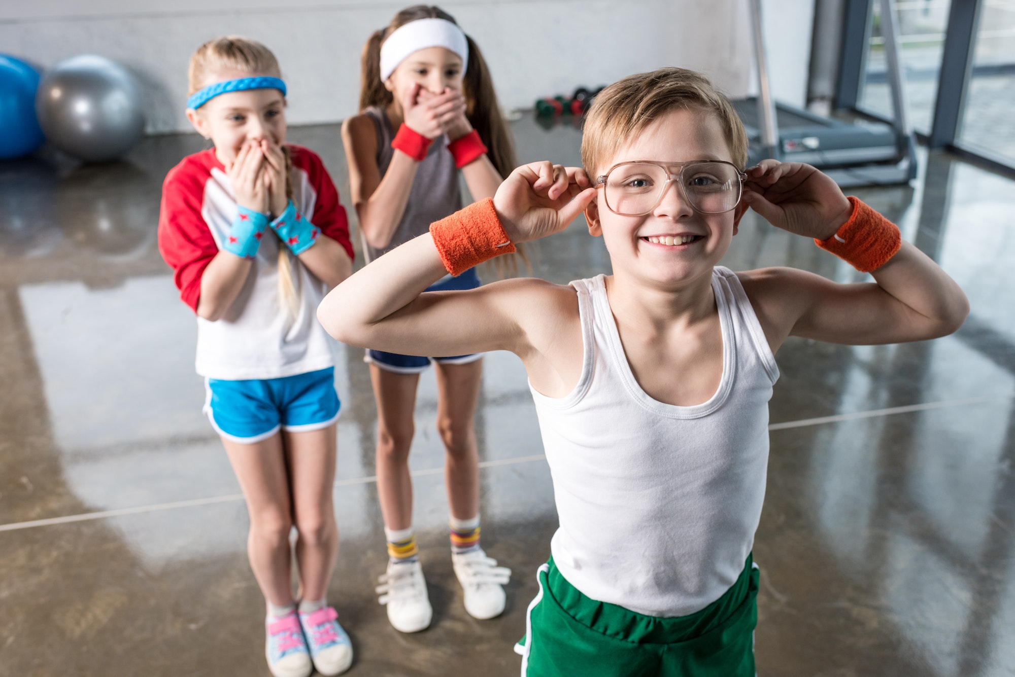 adorable kids in sportswear fooling around at fitness studio, children sport concept
