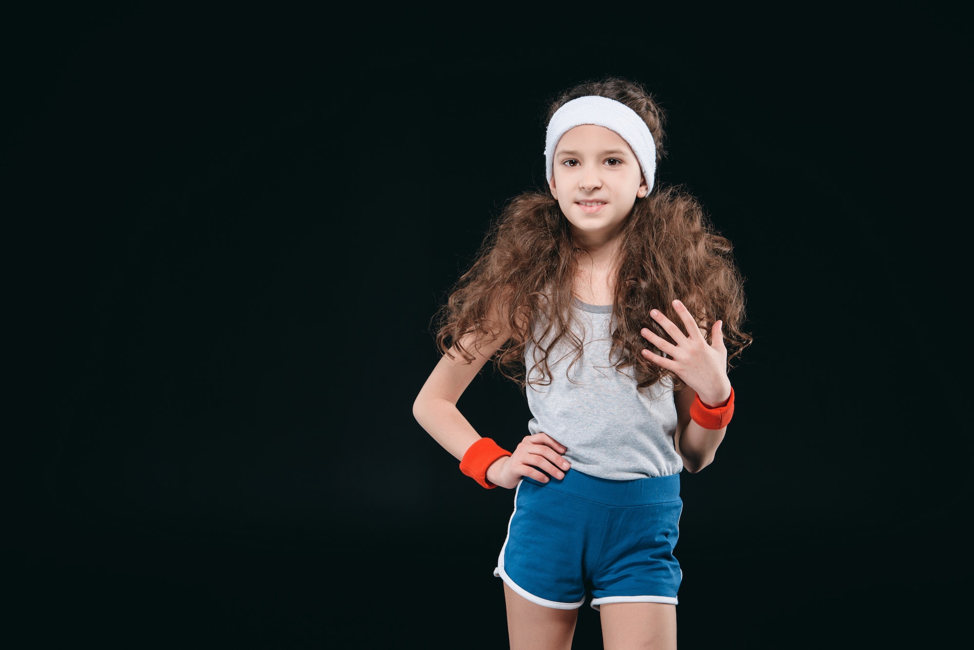 girl posing in sportswear isolated on black. 12 year old kids, children sport concept